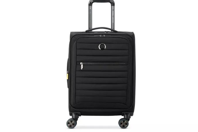 Travelpro Maxlite 5 carry-on next to a dorm room desk, packed open