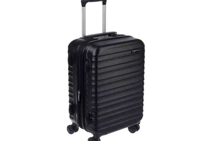 Level8 Venture Backpack sitting upright next to a packed carry-on