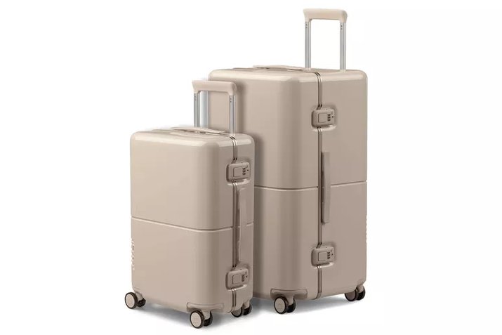 hard-shell carry-on open on a hotel bed, packed